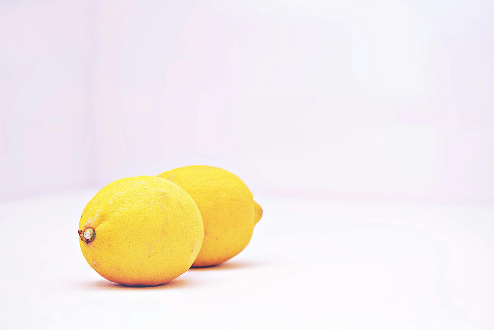 Eine Hand hält einen orangefarbenen Vibrator vor einem minimalistischen violetten Hintergrund, was moderne Sinnlichkeit und Selbstliebe symbolisiert.