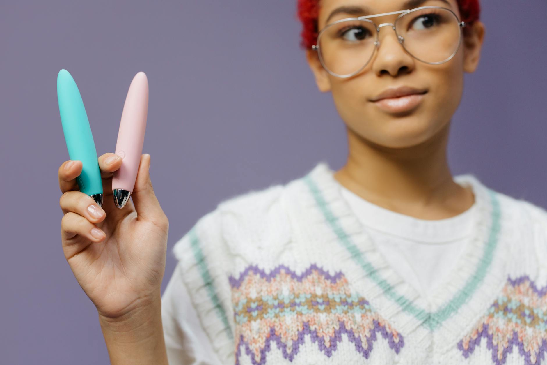 Woman holding vibrators against a purple background, symbolizing returning to pleasure after depression treatment